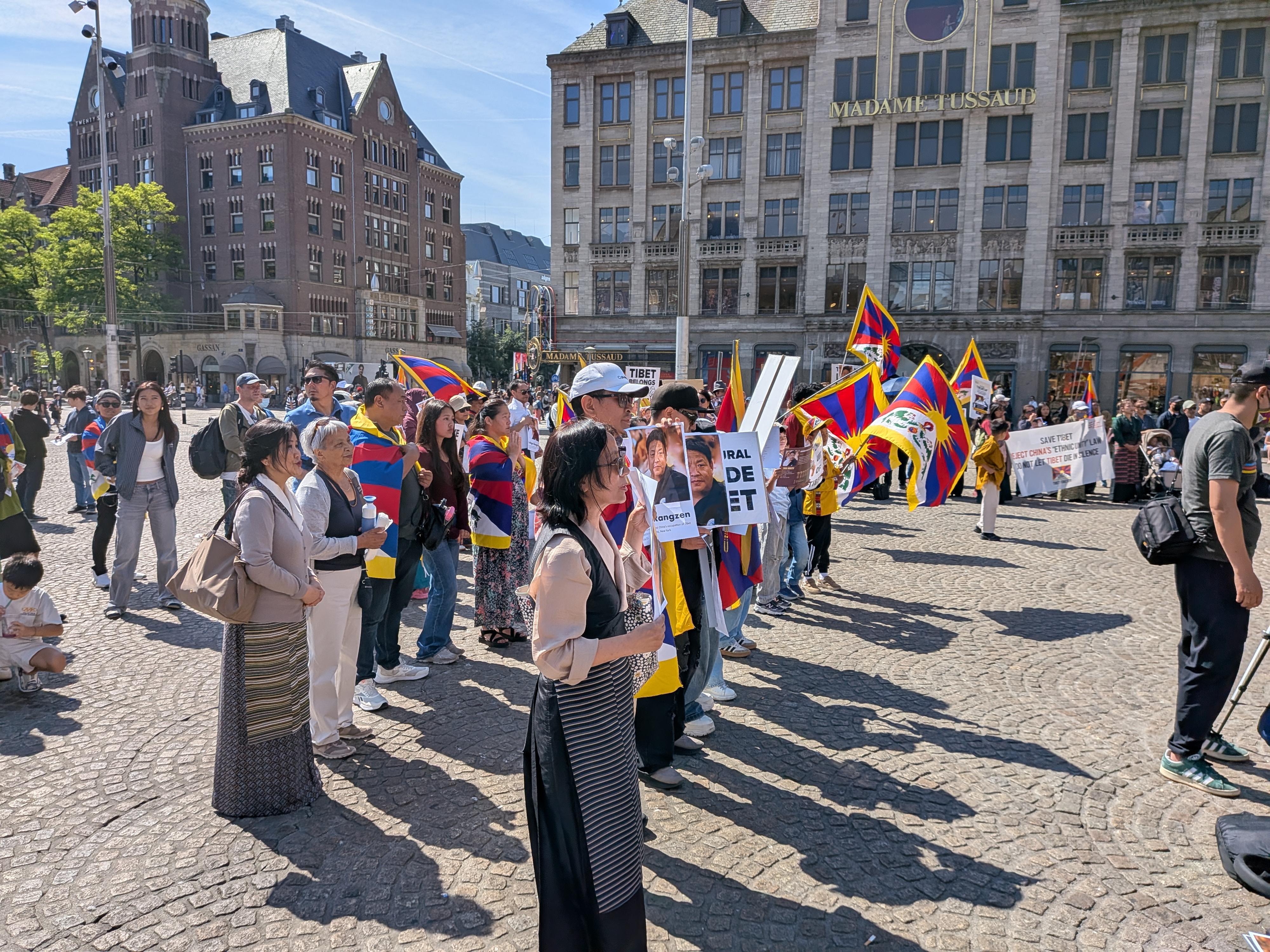 Deelnemers op de Dam met talrijke Tibetaanse vlaggen en portretten van Lobga Rangzen