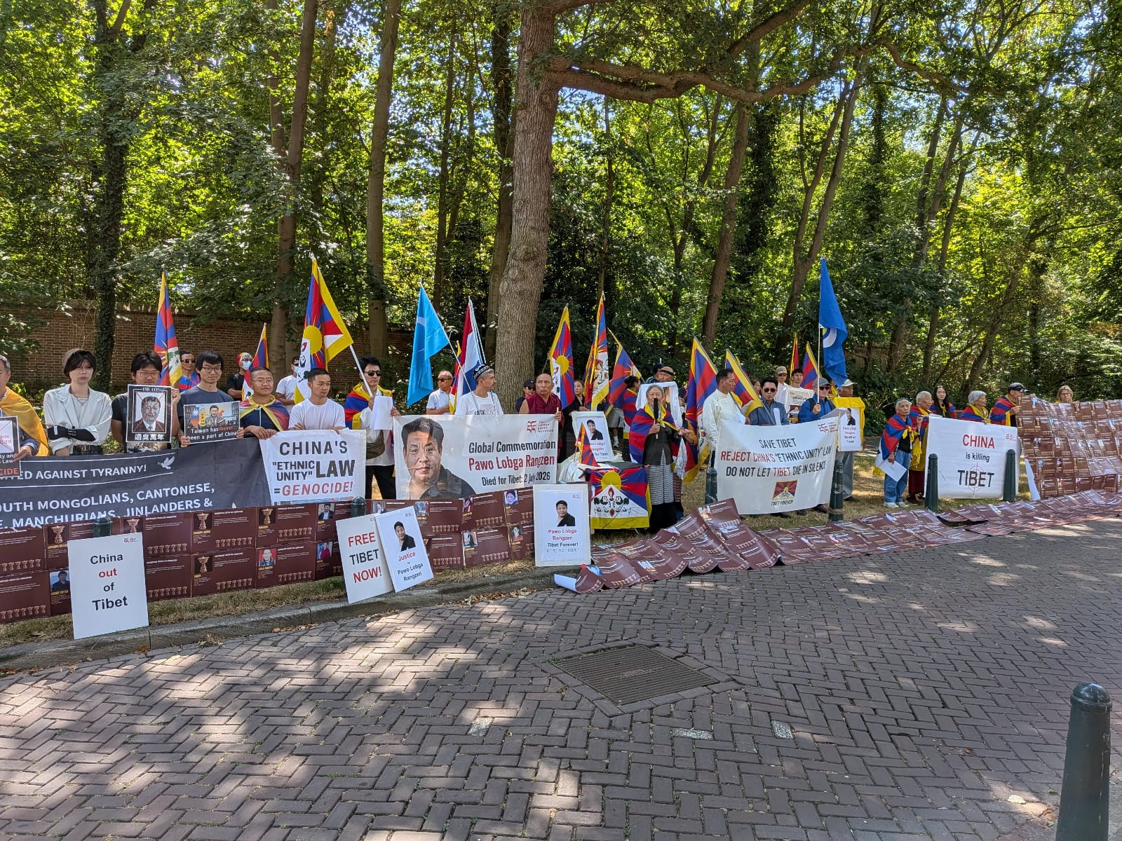 Demonstranten met Tibetaanse vlaggen, spandoeken en portretten van Pawo Lobga Rangzen bij de Chinese ambassade in Den Haag